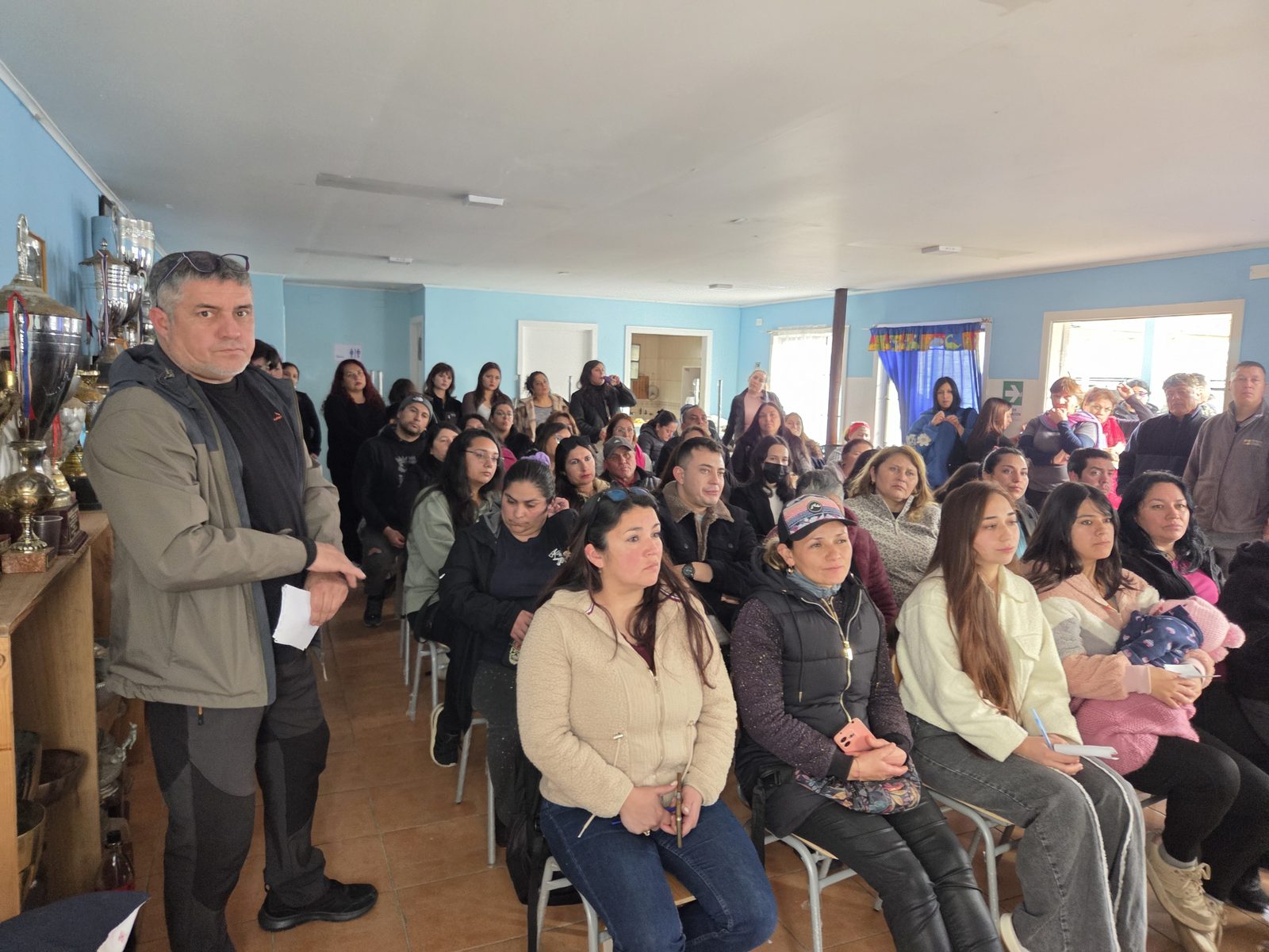 La conducción del comité se dirige a las familias durante la asamblea
